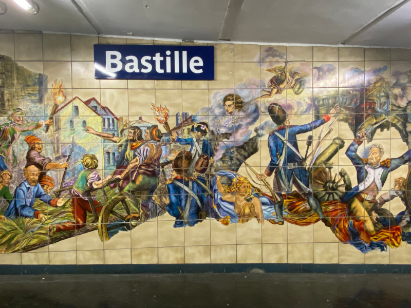 （メトロ・バスチーユ駅の壁には、バスチーユ牢獄襲撃の様子をあらわすタイルがあります。）